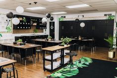 an empty restaurant with tables, chairs and plants