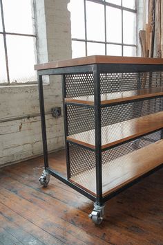 a metal and wood shelf in an empty room with lots of windows on the side