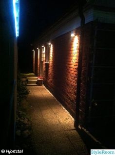 a brick building with lights on the side of it in the dark at night time