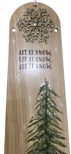 a wooden sign with a pine tree on it and the words let it snow, let it snow