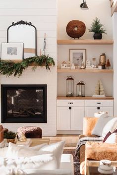 a living room filled with furniture and a fire place covered in greenery next to a white brick wall