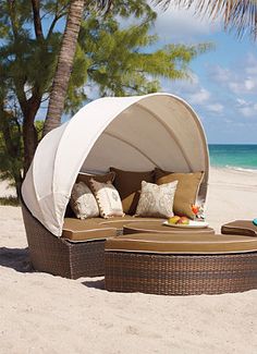 an outdoor day bed on the beach with palm trees