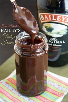 a glass jar filled with chocolate pudding next to a bottle of bailey's