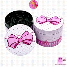 two round boxes with pink bows and polka dots on the top one has a black lid