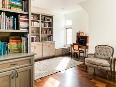 a living room filled with furniture and bookshelves next to a dining room table