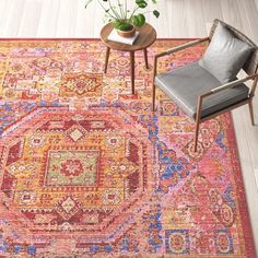 an area rug with a chair, table and potted plant