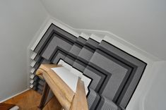 a room with black and white striped wallpaper on the walls next to a wooden table