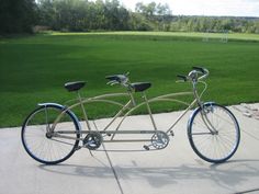 two bicycles are parked on the sidewalk in front of some grass