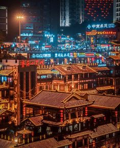 an aerial view of a city at night with lots of buildings and lights in the background