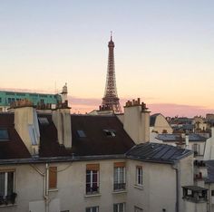 the eiffel tower is seen in the distance from some buildings with rooftops