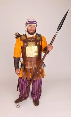 a man dressed as a roman soldier holding two spears