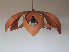 a wooden light hanging from a ceiling with an abstract design on the top and bottom