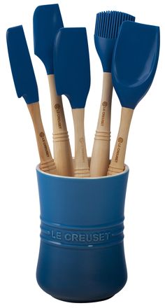 a blue cup filled with wooden utensils and spatulas on top of each other