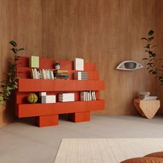 an orange book shelf with books on it in a living room next to a plant