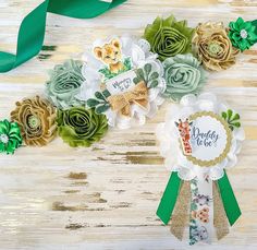 some paper flowers and ribbons on a wooden table with green ribbon around them that says happy new year