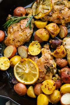 lemon rosemary chicken thighs in a cast iron skillet with potatoes and lemons on the side