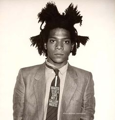 a black and white photo of a young man with dreadlocks on his head