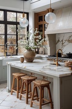 a kitchen with marble counter tops and wooden stools in front of an open window