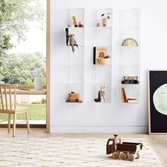 a toy car is sitting on the floor in front of a wall with bookshelves