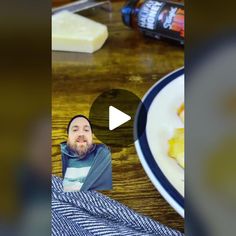 a man with a beard sitting in front of a plate of food