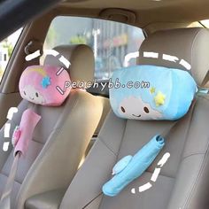 two stuffed animals sitting in the back seat of a car with headrests on