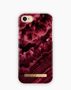 an iphone case with red flowers and gold lettering on the bottom, in front of a white