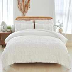 a bed with white comforter and pillows in a room