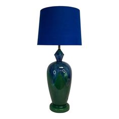 a blue lamp sitting on top of a green table next to a blue lampshade