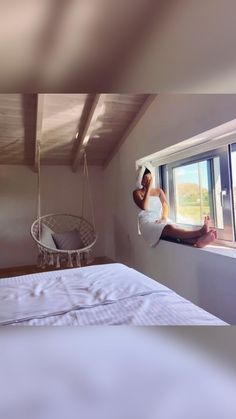 a person hanging upside down on a bed in a room with a hammock