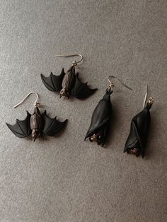 three bats hanging from earrings on the floor