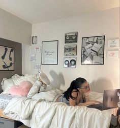 a woman laying in bed with her laptop