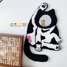 a black and white cat rug sitting on top of a table next to a wooden box