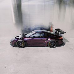 a purple sports car parked in front of a building