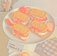 there are waffle sandwiches on the plate with strawberries and peaches next to it