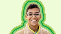 a young boy wearing glasses and a jacket smiling at the camera with a green background