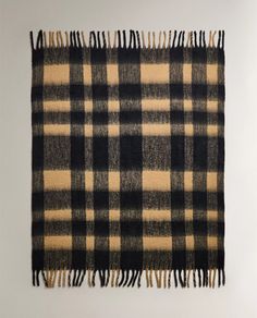 a black and tan plaid blanket hanging on a wall