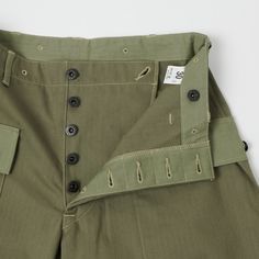 Based on the iconic USMC standard issue ‘monkey pant’, the 1097 from Warehouse & Co masterfully captures the original authentic feel of a military icon. Cut from a 100% cotton HBT fabric, this olive drab trouser is a loose fitting, high rise model which is luxuriously comfortable and obscenely functional. The softness of the cotton is met with heavy duty manufacturing techniques as illustrated by double felled seams on the inside and outer leg, reinforced custom branded buttons, and a crossover Dapper Outfit, Sewing Details, Army Pants, Comfortable Pants, 8 Ball, Clothes Shopping, Utility Pants, Clothing Co, Herringbone