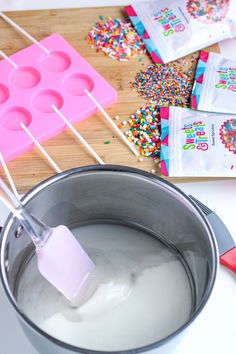 an ice cream maker with sprinkles and candy bars on the stick next to it