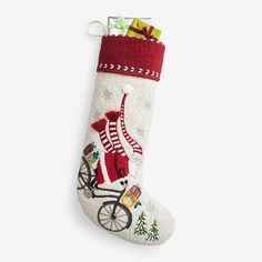 a christmas stocking with a santa riding a bike on the front, and presents in the back