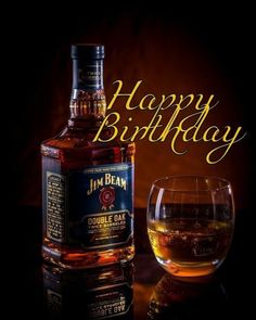 a bottle of whiskey next to a glass filled with liquid and the words happy birthday