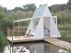 a tent is set up on the dock for people to sit and relax in it