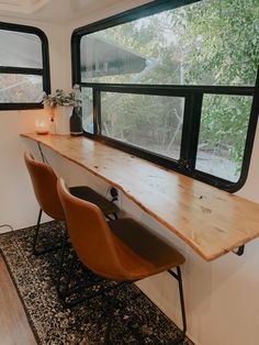 two chairs are sitting in front of a desk with a window on the opposite side