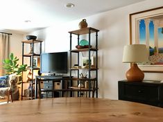 a living room filled with furniture and a flat screen tv sitting on top of a wooden table