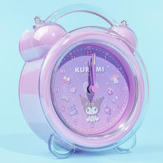 a pink alarm clock with hello kitty faces on it's face is shown in front of a blue background