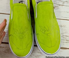 someone has drawn the face on their neon green slip - ons with white paint