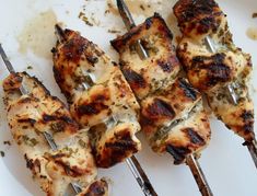 grilled chicken skewers are sitting on a plate