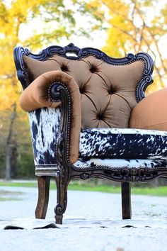 an old fashioned chair with cowhide upholstered on it's back and arms