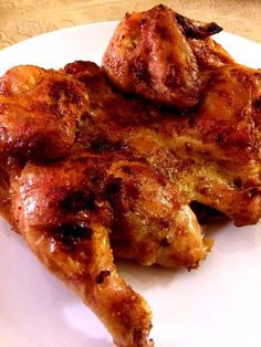 two pieces of chicken sitting on top of a white plate