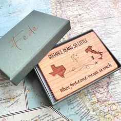 two wooden boxes sitting on top of a map with the words distance means so little