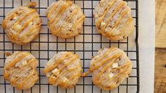 six cookies with peanut butter drizzled on them sitting on a cooling rack